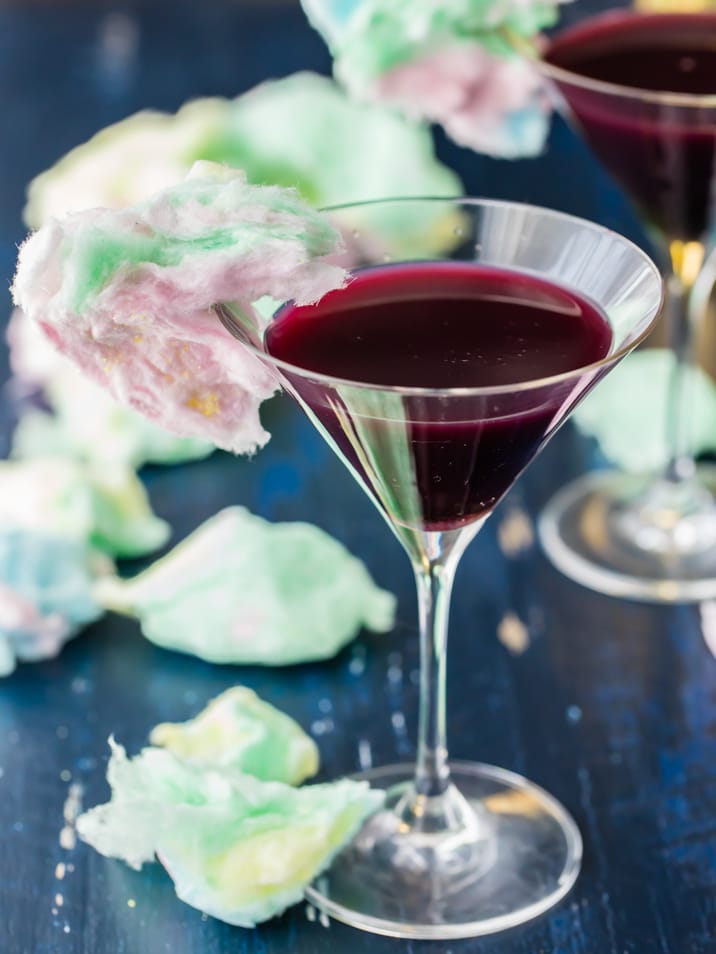 cotton candy garnish on martini glass filled with grape juice.