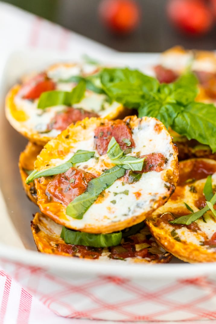 plate of tortillas covered in cheese, sauce, and tomatoes