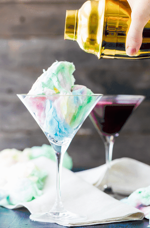 GIF of cotton candy disappearing in glass as cocktail is poured