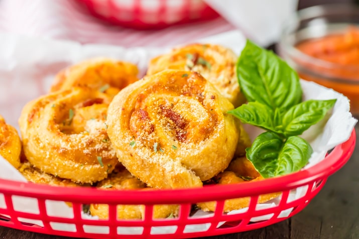 a red basket with stuffed pepperoni pizza rolls
