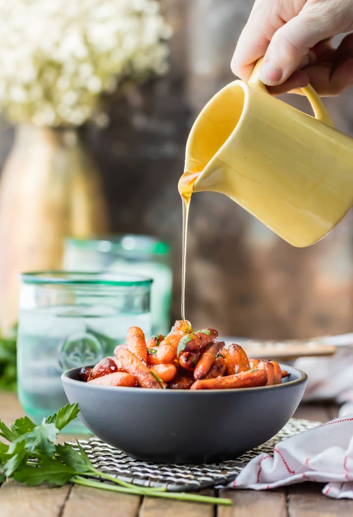 glaze being poured over bowl of carrots