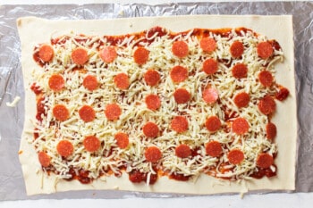 sauce, cheese, and pepperoni spread over rolled out dough.