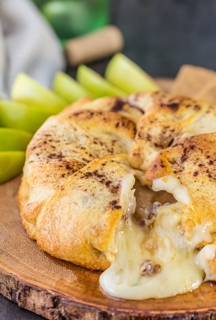 apple pie baked brie on wooden board with melted cheese