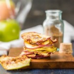 cinnamon sugar apple chips stacked up on a wooden cutting block