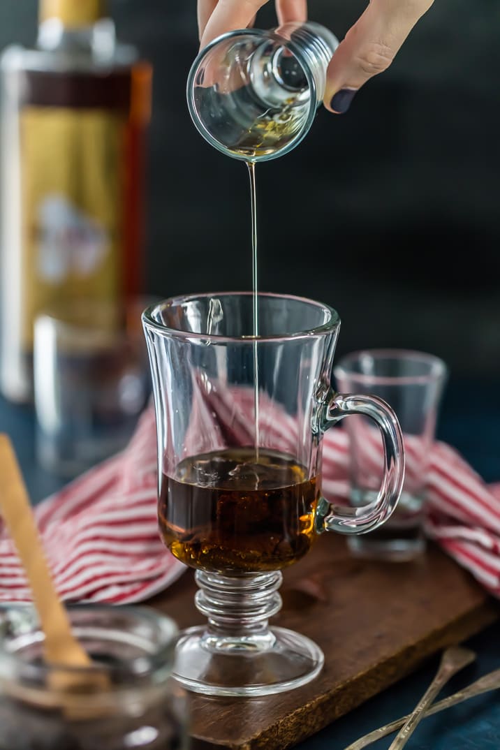 Pouring a shot of rum into a clear glass