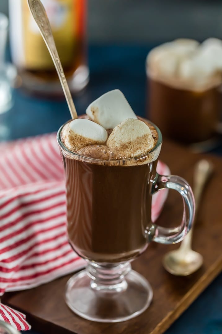 A clear mug filled with chocolate hot buttered rum, topped with marshmallows