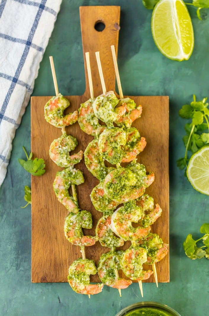 above shot of pesto shrimp skewers on wooden board