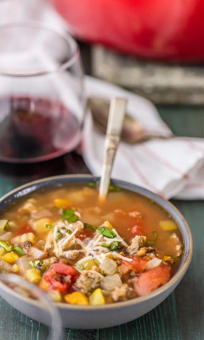 A bowl of soup filled with sausage, lentils, and veggies