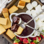 a bowl of chocolate fondue with strawberries and marshmallows.