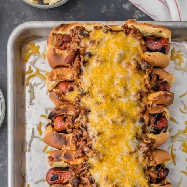 This Chili Dog Recipe all baked together on a sheet pan is the BEST Chili Dog Recipe ever! These Chili Cheese Dogs topped with the best hot dog chili recipe. If you're in the mood for comfort food; toasted buns, grilled hot dogs, best ever chili, and of course tons of cheese; this recipe is for you!