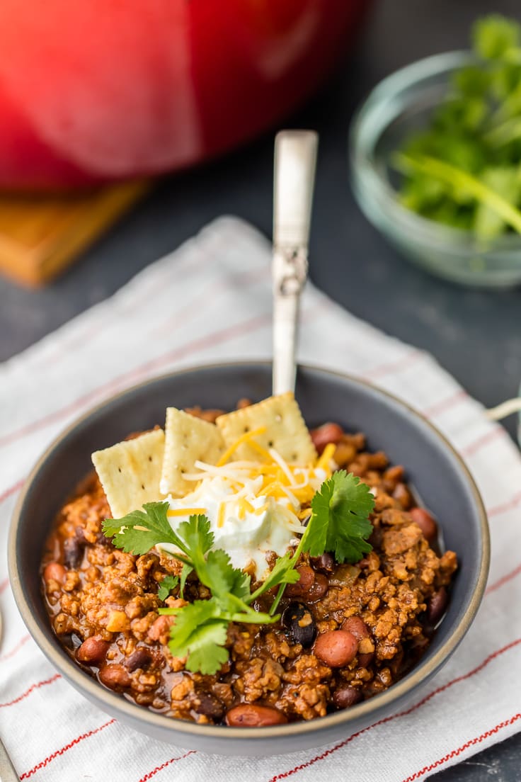 bowl of the best chili topped with sour cream and crackers