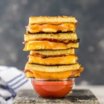 a stack of grilled cheese with bacon and tomato sauce.