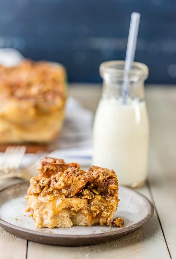 Apple Pie Bread Pudding recipe on a plate, with a small glass jar filled with milk in the background
