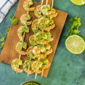 pesto shrimp skewers on a wooden cutting board