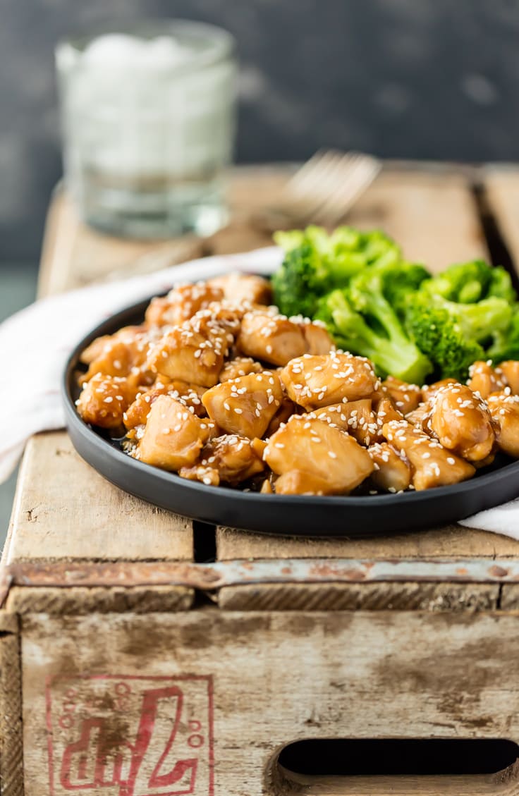 a plate of teriyaki chicken set on a wooden crate
