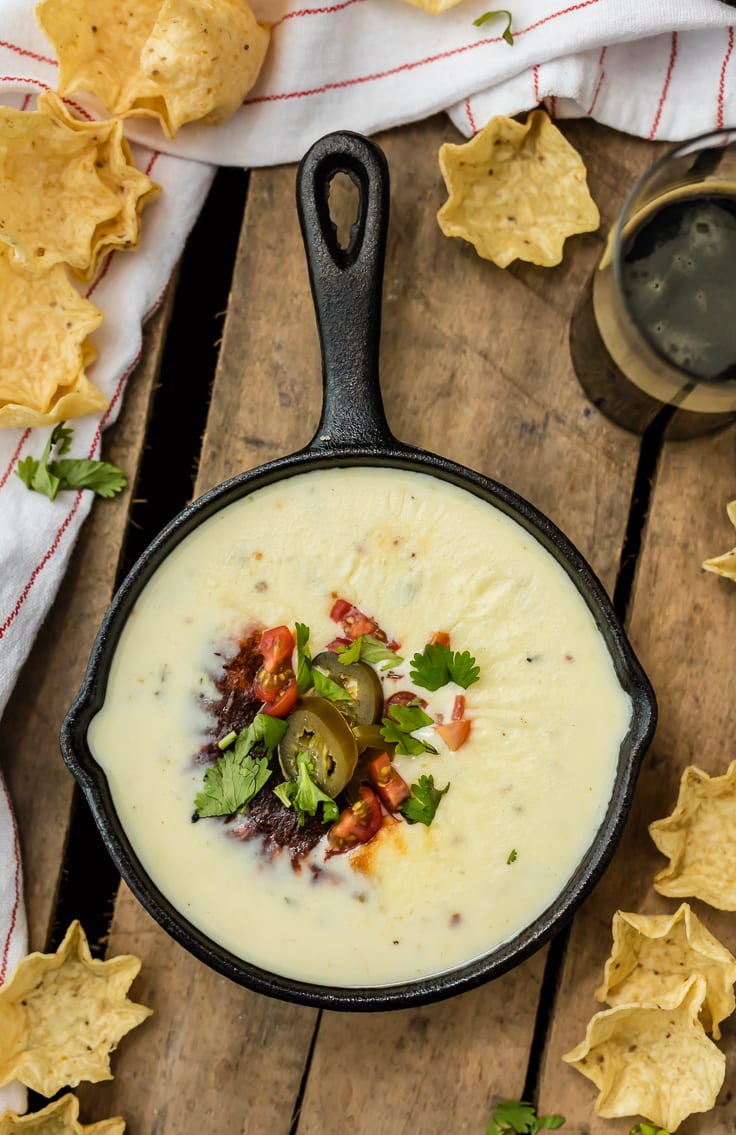 This Queso recipe is the most delicious white cheese dip you will ever taste. If you're looking for an easy queso dip recipe, you've come to the right place. No velveeta, just real quality cheese and ingredients melted together and ready to dip. Just like what you get at your favorite Mexican restaurant! skillet of cheese dip on a table top