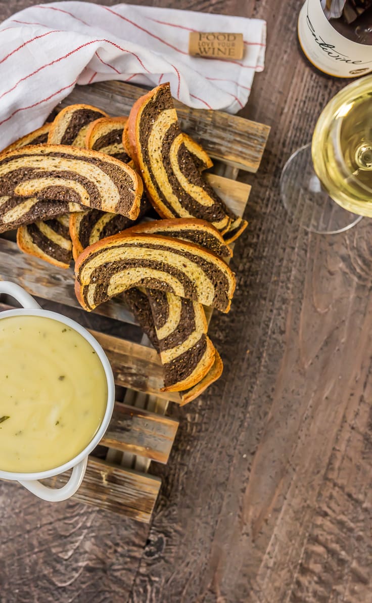 crostini slices, fondue, and glasses of wine on a table