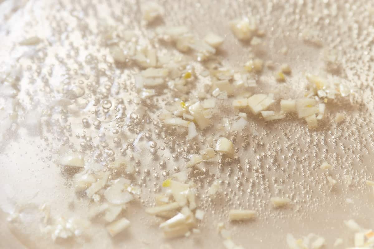 Chopped garlic cooking in a pan.