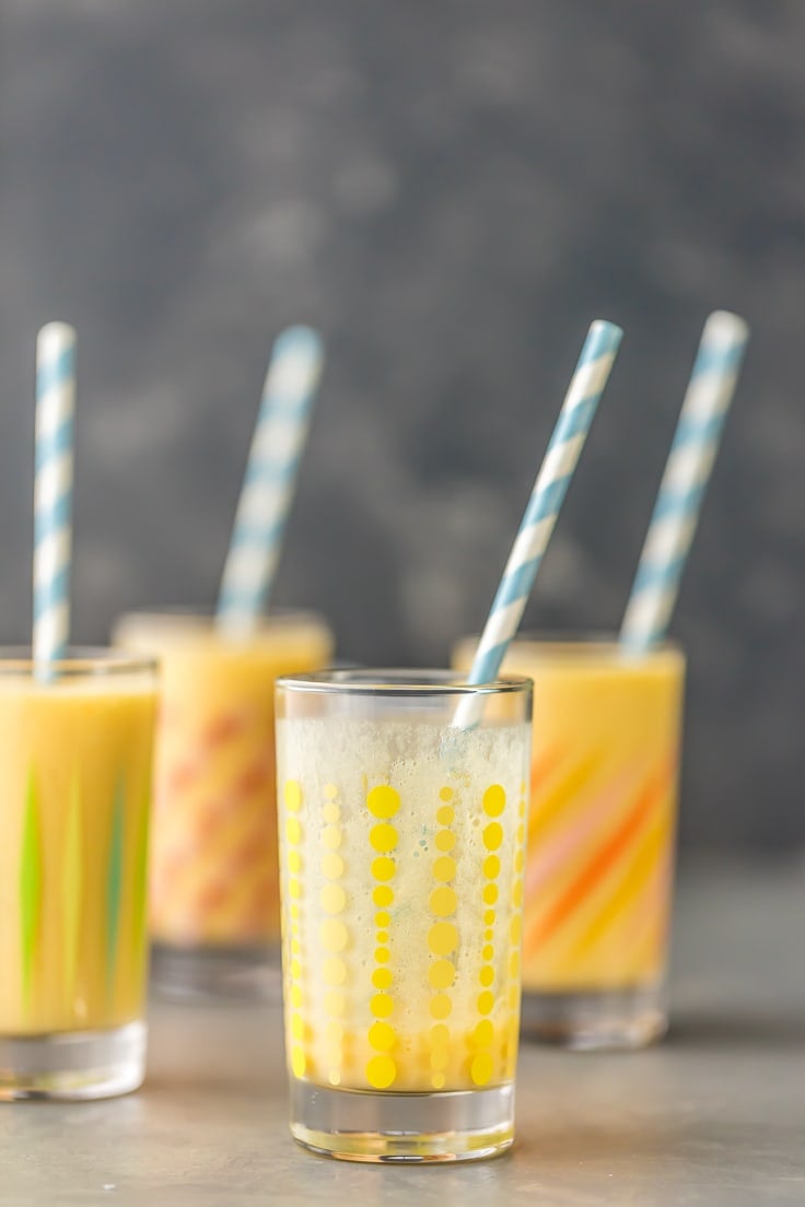 four glasses with simple mango smoothies
