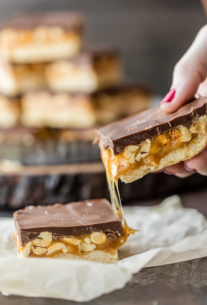 Cookie bars made with layers of shortbread, caramel, peanuts, and chocolate