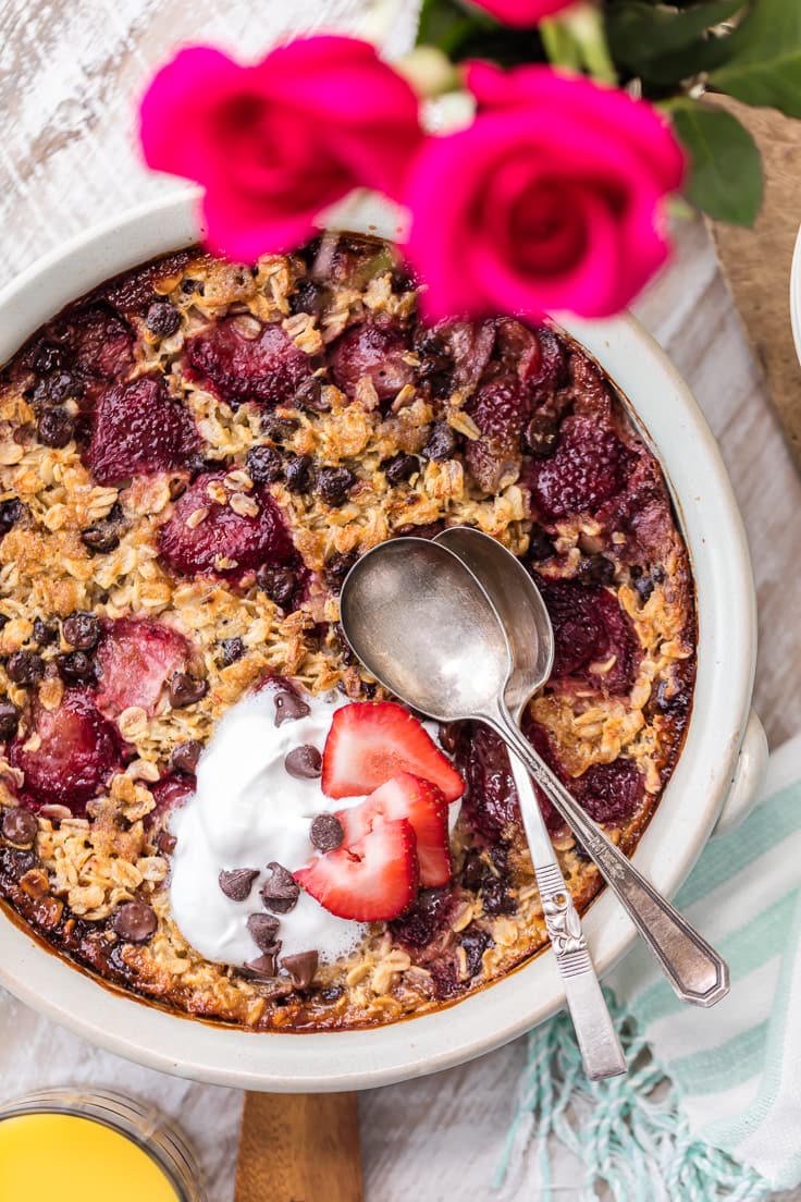 chocolate covered strawberry baked oatmeal recipe in a large white dish with two spoons