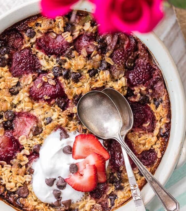 This Baked Oatmeal recipe is the perfect blend of strawberries and chocolate, for a special chocolate covered strawberry Valentine's Day breakfast! Take those sweet flavors and make breakfast in bed to start the day off right. This strawberry chocolate oatmeal is so easy and so tasty!