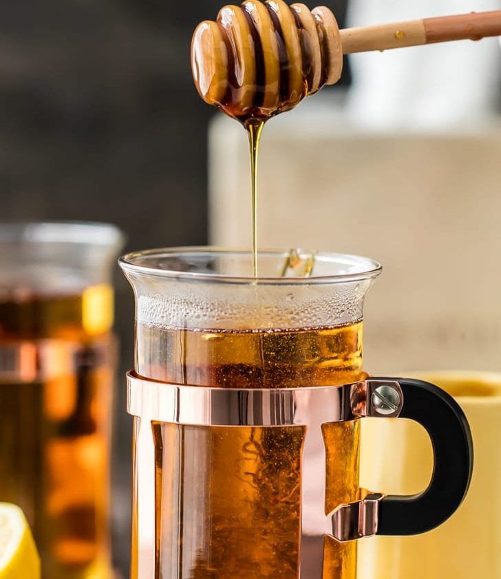 pouring honey into a hot toddy for a cough