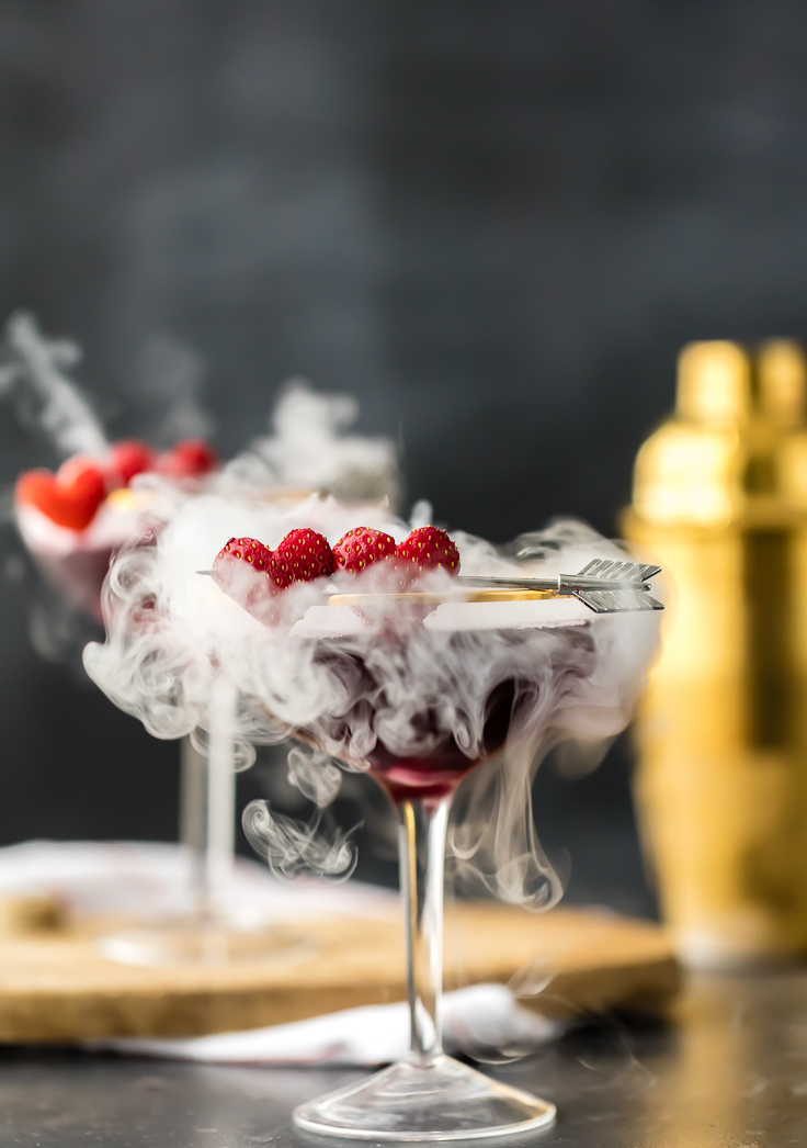 two berry pomegranate martinis with dry ice smoke wafting out