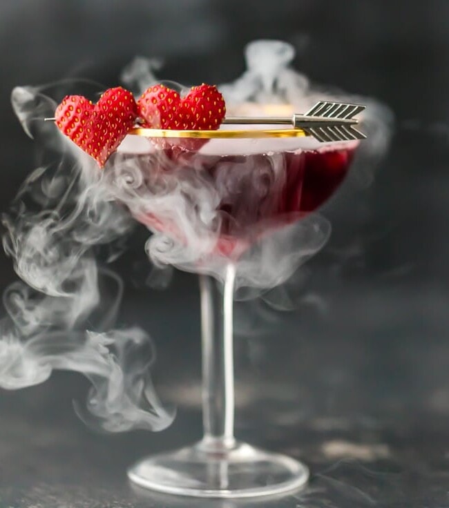 This Pomegranate Martini is the perfect Valentine's Day cocktail! It's a tasty triple berry martini with strawberry vodka, Chambord black raspberry liqueur, and pomegranate juice. Plus there's a little dry ice trick to really put on a show. It's one of my favorite Valentine's Day drinks!