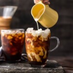 creamer being poured into coffee mug