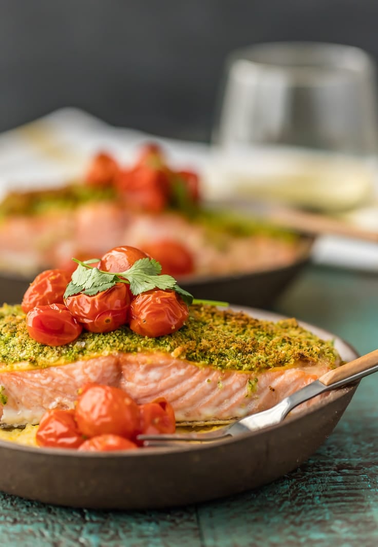 plates of herb crusted baked salmon topped with roasted tomatoes