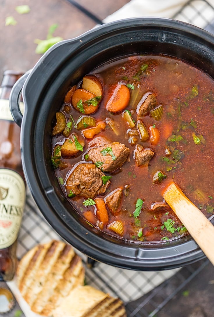 Irish beef stew cooking in a slow cooker, with chunks of beef, carrots, and potatoes 