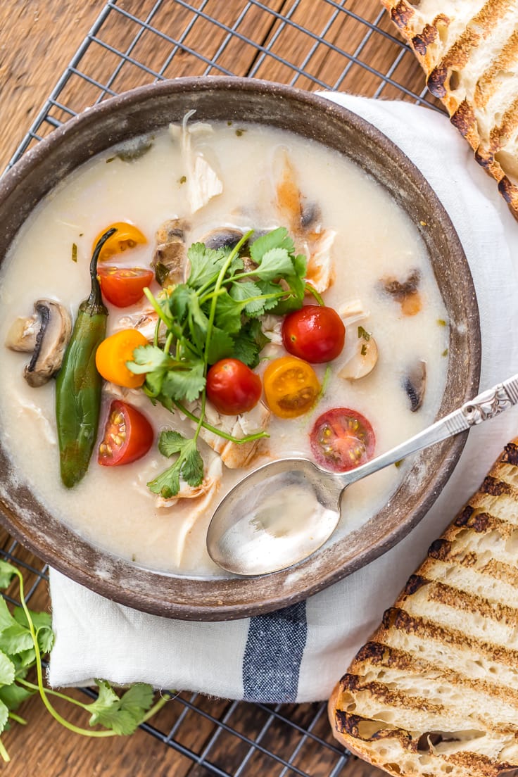 bowl of soup with mushrooms, tomatoes, chllis, cilantro, and more