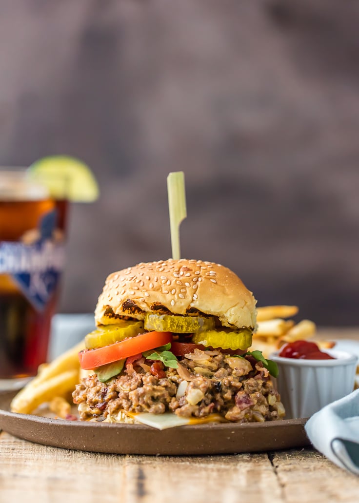 Slow Cooker Bacon Cheeseburger Sloppy Joes will wow the entire family! This easy crock pot sloppy Joes recipe is creamy, delicious, and loved by all. a large serving of slow cooker bacon cheeseburger sloppy Joes on a sesame seed bun