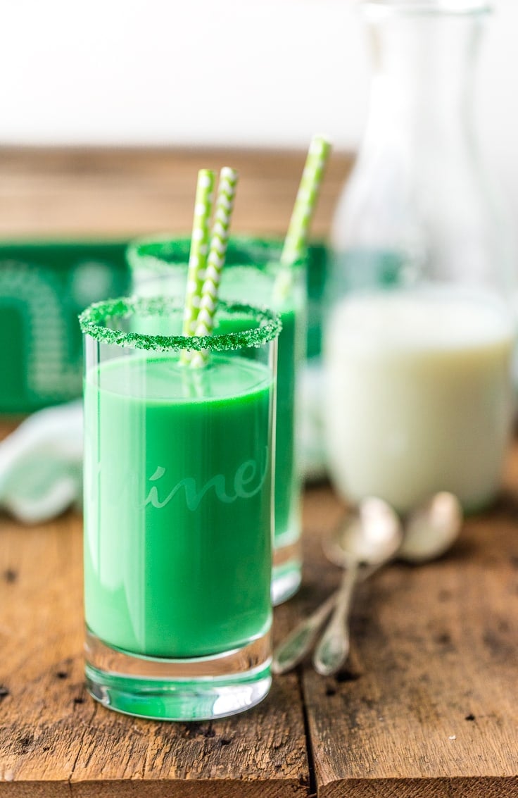 a jug of milk in background, two glasses of green milk in foreground