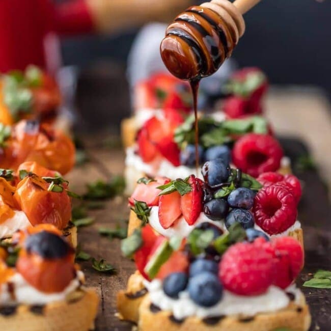 balsamic reduction being drizzled onto brushetta