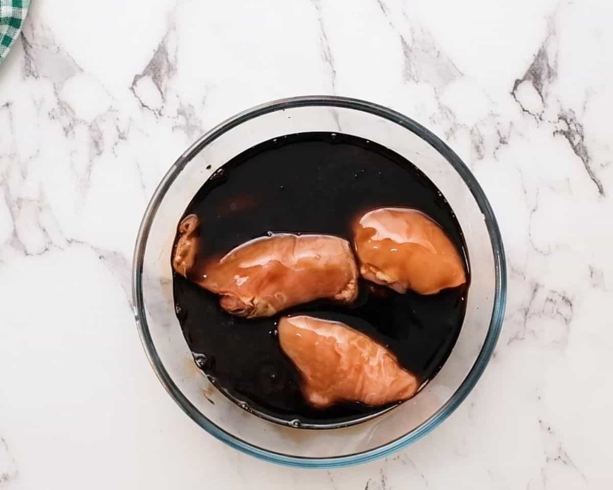 Chicken marinating in balsamic vinegar.
