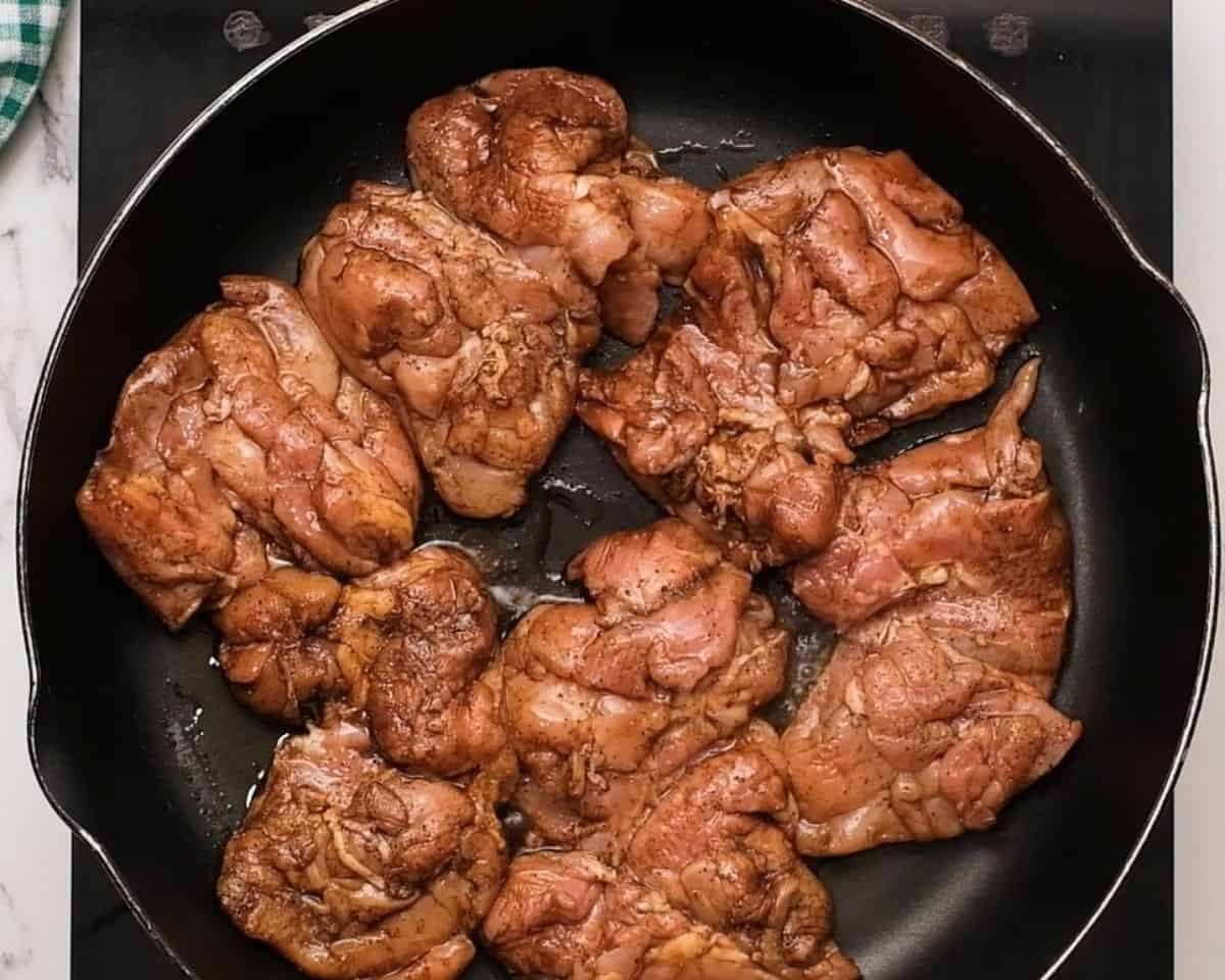 Searing chicken in a pan.