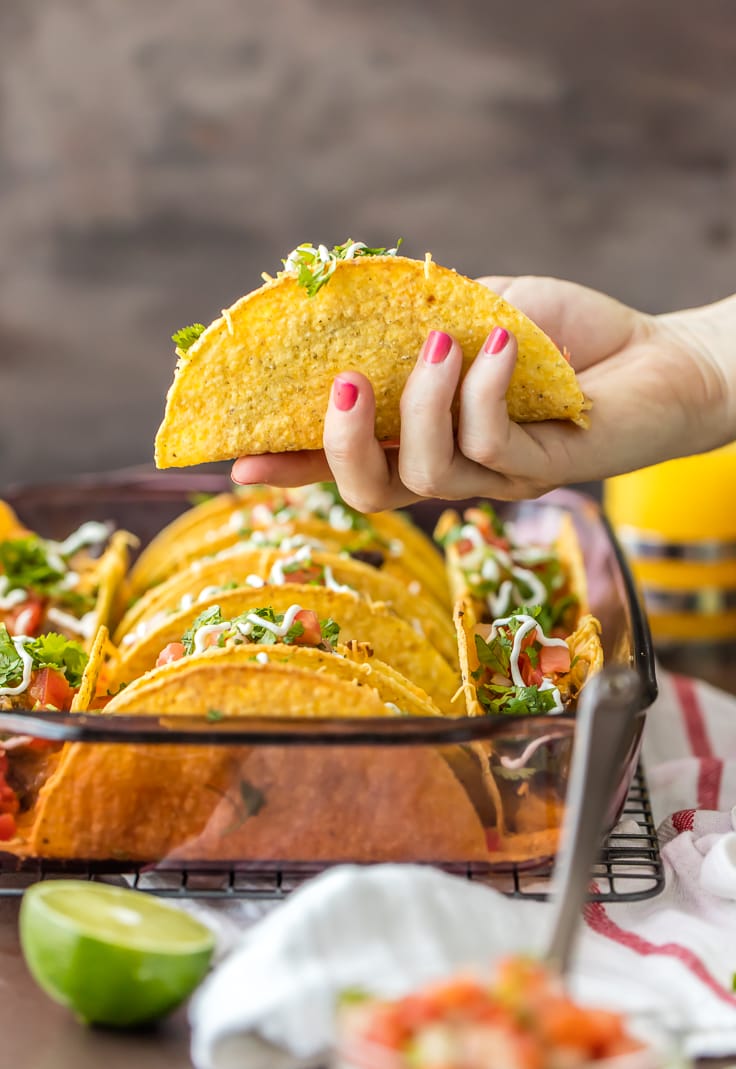 a hand holding a taco