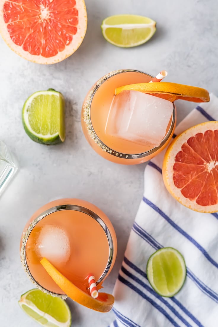 margaritas viewed from above with slices of limes and grapefruits