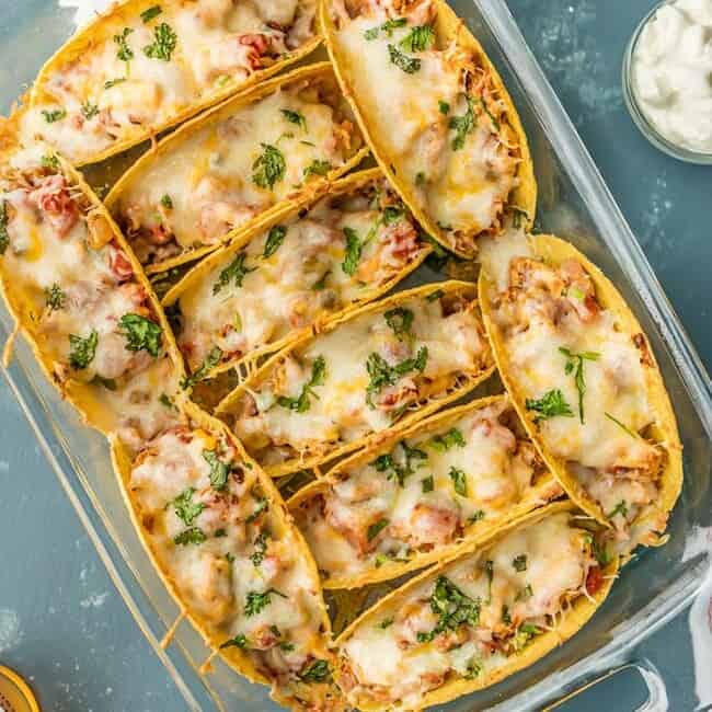 SUPER EASY Oven Baked Spicy Chicken Tacos make a weekly appearance on our table. All the flavor and none of the stress. ALL THAT MELTED CHEESE! Perfect Chicken Tacos recipe for a crowd on Family Mexican Night!