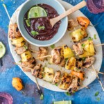 grilled pineapple skewers with a sauce on a plate.