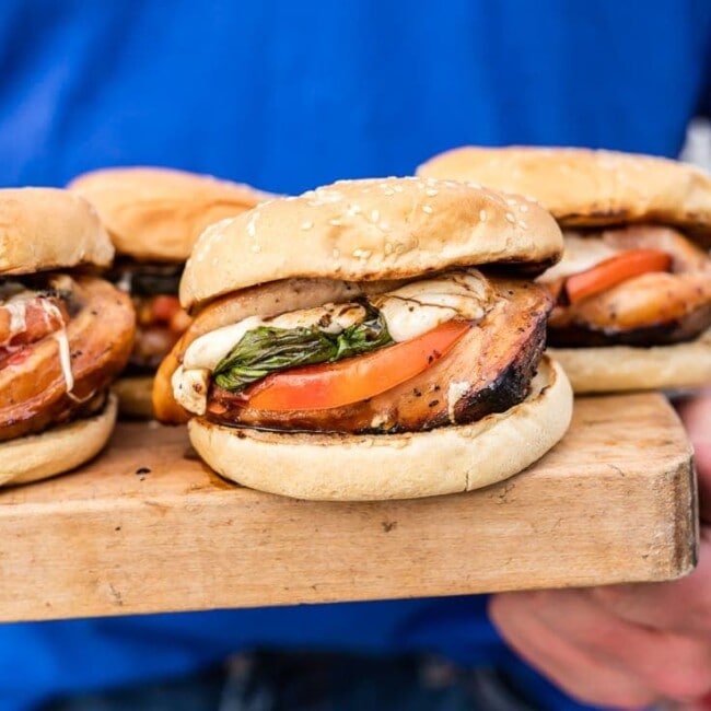 caprese chicken sandwiches on a wooden plate