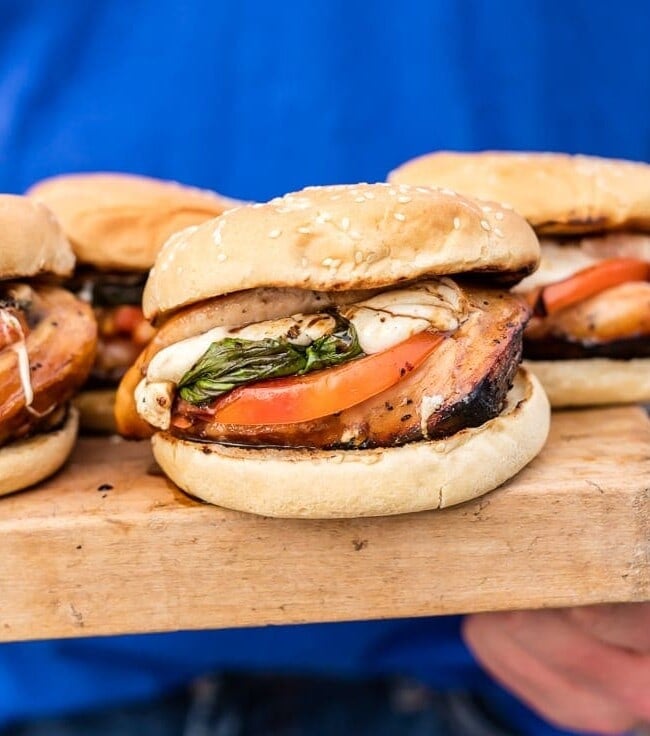 caprese chicken sandwiches on a wooden plate