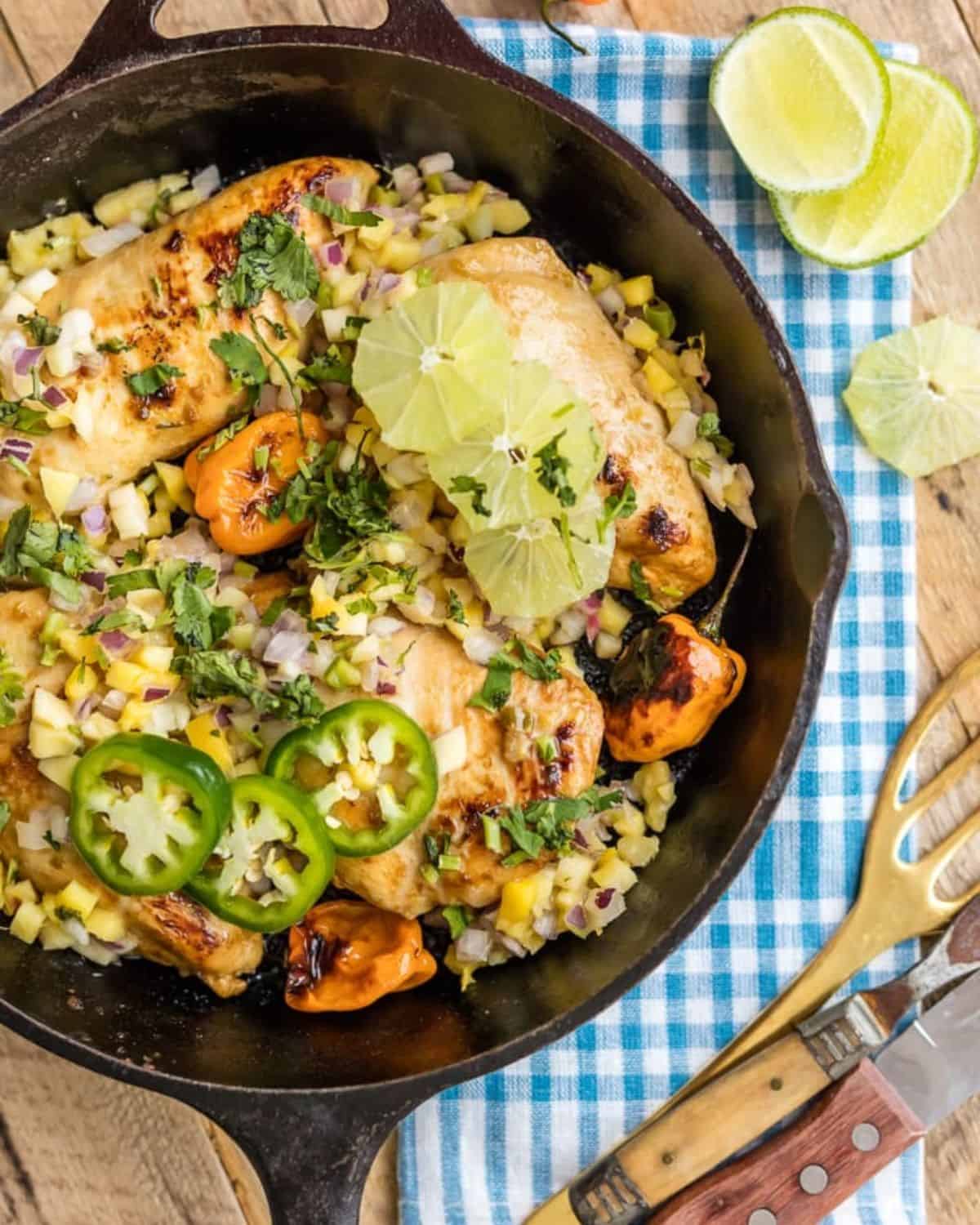 Jerk Chicken with Mango Salsa is a surprisingly easy dish. Make this One Pan Caribbean Jerk Chicken recipe in just 15 minutes! Pair this flavorful chicken with rice for a delicious and easy weeknight meal! One Pan Caribbean Jerk Chicken with Mango salsa in a skillet.
