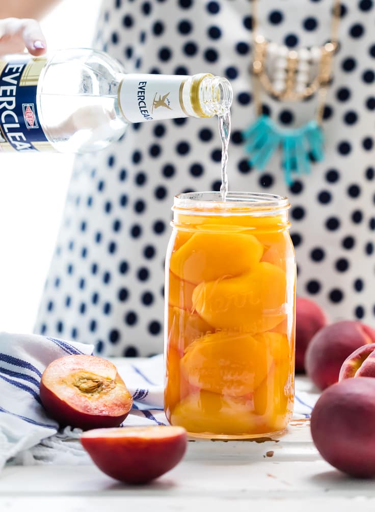 pouring everclear into a jar of peaches