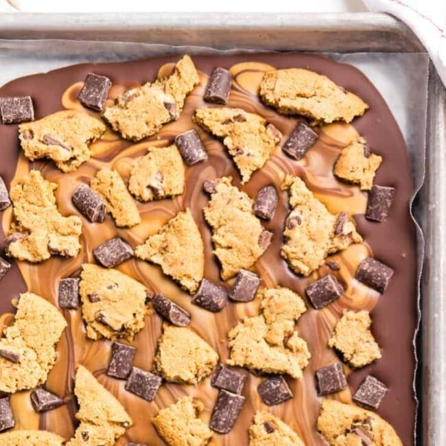 Peanut Butter Chocolate Chip Cookie Bark is the ULTIMATE easy dessert recipe! Only 4 ingredients stand between you and this party favorite. Loaded with peanut butter, milk chocolate, dark chocolate chunks, and chocolate chip cookies! Great last minute sweet treat for tailgating.