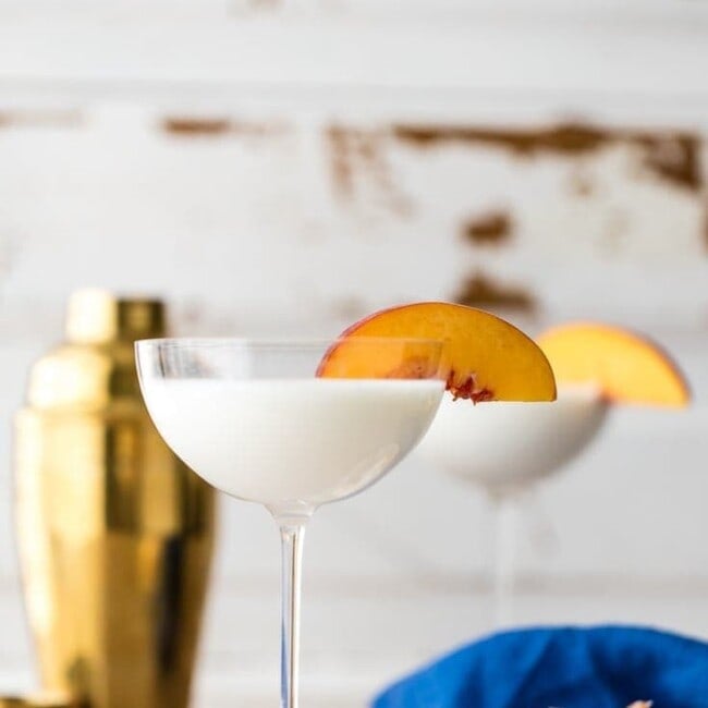 gooey butter cake martini with sliced peach on rim