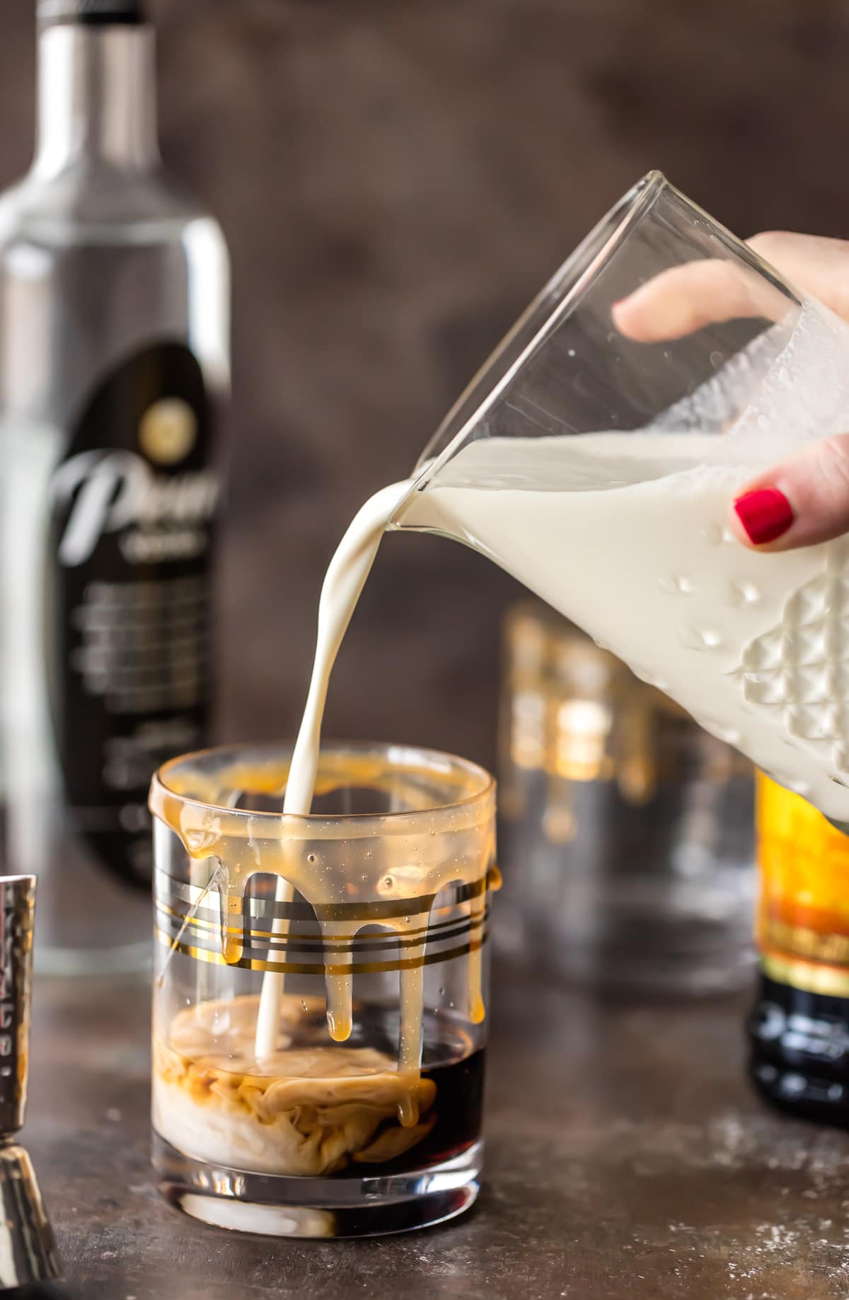 pouring creamer into a cocktail glass