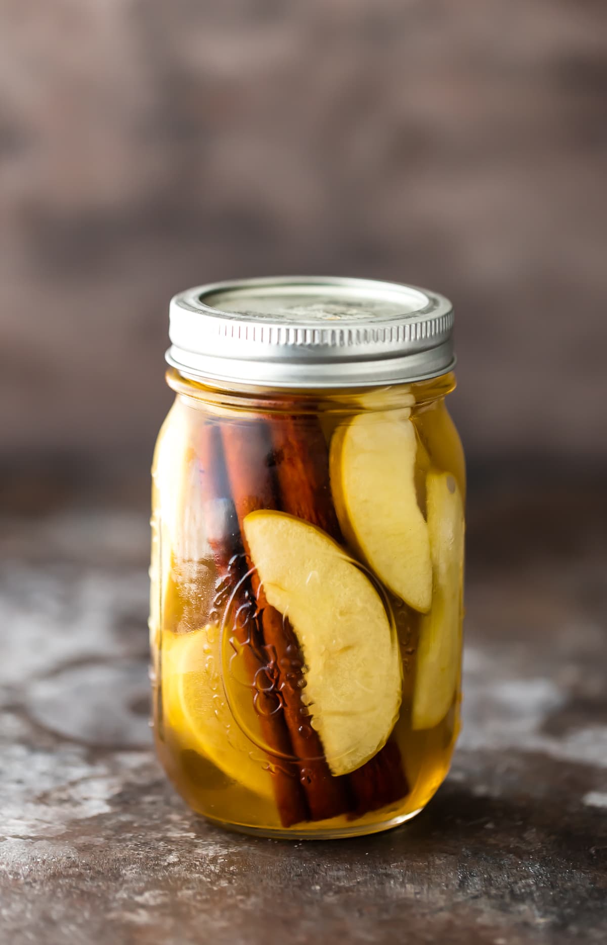 Homemade Vodka Recipe: A mason jar filled with apple slices, cinnamon sticks, and vodka